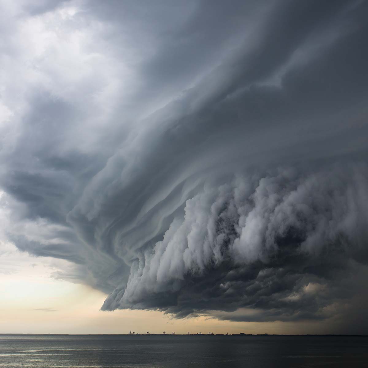 The sun peeks through the clouds, creating a mesmerizing blue sky amidst the storm, an impressive display of nature's weather backdrop.